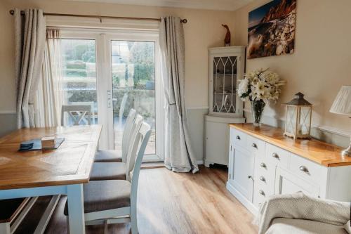 een eetkamer met een tafel en een vaas met bloemen bij Ocean City Family Home in Plymouth