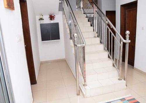 a staircase with silver railings in a house at Résidence Doux in Dakar
