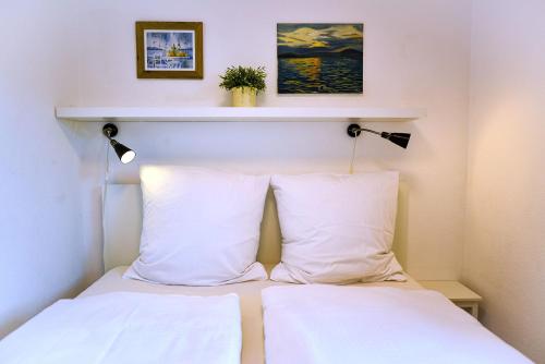 a bed with two white pillows in a room at Haus Seehund HD04 in Cuxhaven