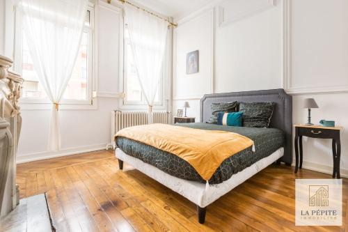 una camera bianca con un letto e una finestra di Residence Belle Etoile a Valenciennes