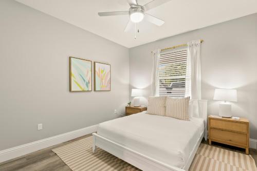 a white bedroom with a bed and a window at NEW! Canopy Cabana - Luxury Downtown Apartment in Safety Harbor