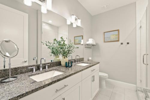 a bathroom with two sinks and a large mirror at NEW! Canopy Cabana - Luxury Downtown Apartment in Safety Harbor
