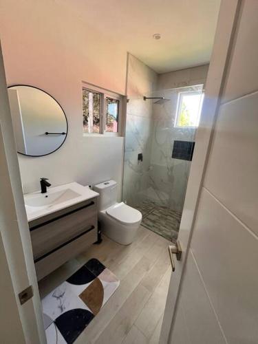 a bathroom with a toilet and a sink and a shower at Modern condo close to Rodney Bay and Airport in Gros Islet
