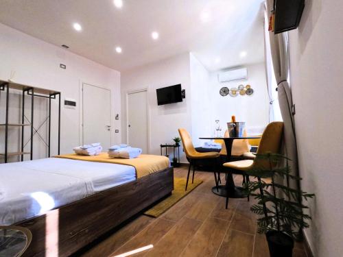 een slaapkamer met een bed en een tafel met een bureau bij BlackWoody Contemporary Rooms - Napoli Centro Storico in Napels