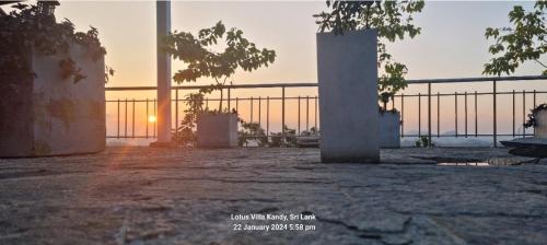 a view of the sunset from a patio with a fence at Lotus Villa Kandy in Peradeniya
