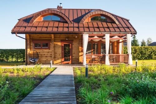 a house with a wooden walkway in front of it at Sala Resort Plateliai & SPA in Plateliai