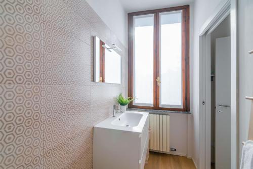 bagno con lavandino bianco e finestra di La Corte 48 - Pavia City - by Host4U a Pavia