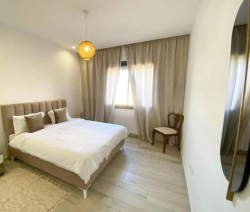 a bedroom with a white bed and a window at fabuleux S2 a la Marsa in La Marsa