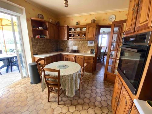 - une cuisine avec une table, une table et des chaises dans l'établissement Grande maison de campagne, à Lantic