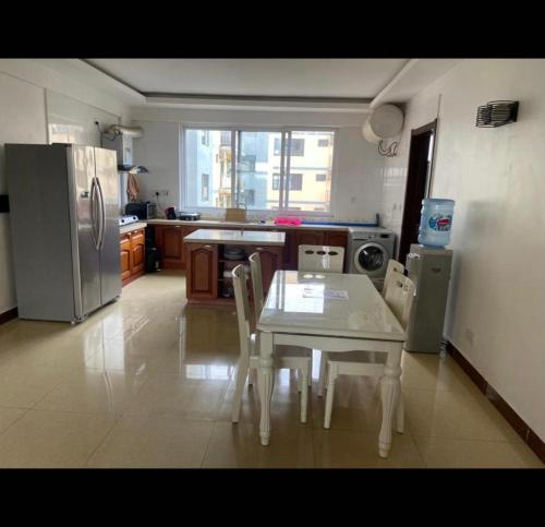 a kitchen with a table and chairs and a refrigerator at Ocean view Home stay in Dar es Salaam