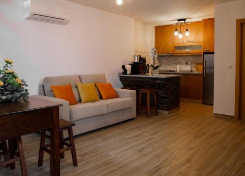 a living room with a couch and a kitchen at Casas do Oiteirinho in Arganil