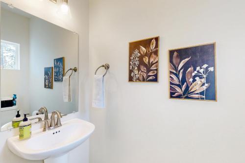 baño con lavabo y 2 pinturas en la pared en Ponderosa Peaks Retreat, en Flagstaff