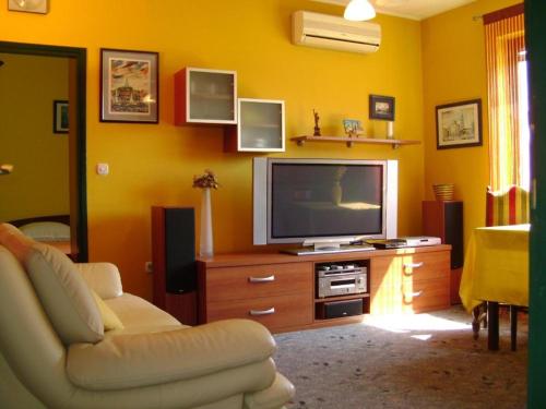 a living room with a television on a wooden dresser at Apartmani Tome in Zadar