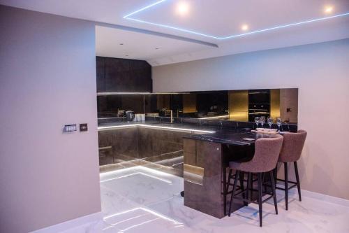 uma cozinha com um bar com bancos e uma banheira em Luxury City Stay: 2-BR Penthouse em Wolverhampton