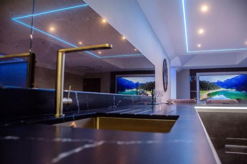 a kitchen with a sink and two windows at Luxury City Stay: 2-BR Penthouse in Wolverhampton