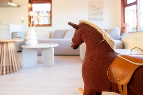 a stuffed horse is standing in a living room at Leva - Logeren in Drenthe in Doldersum