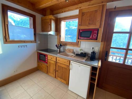 une cuisine avec un évier et un micro-ondes dans l'établissement Appartement à Queige, à Queige