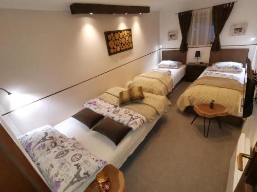 Cette chambre comprend 3 lits et une table. dans l'établissement Planinska idila - uz stazu, à Jahorina