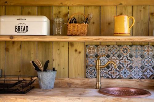 a kitchen counter with a sink and a shelf at Torre Cider Farm in Washford