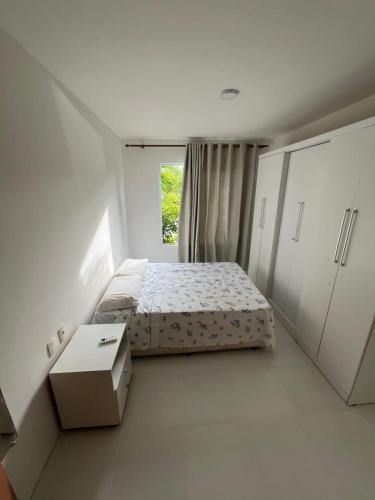 a small bedroom with a bed and a window at Condominio reserva imbassai in Mata de Sao Joao