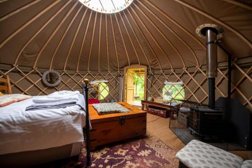 a room with a bed and a clock in a yurt at Torre Cider Farm in Washford