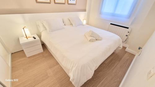 a bedroom with a large white bed with a window at Boutelou playa con vistas al mar in Sanlúcar de Barrameda