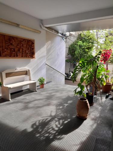 ein Wohnzimmer mit einem Sofa und Topfpflanzen in der Unterkunft Kristi Apartments 01 in Tirana