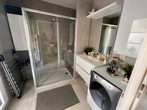 a bathroom with a shower and a washing machine at Cozy Apartment Near the Train Station in Rueil-Malmaison