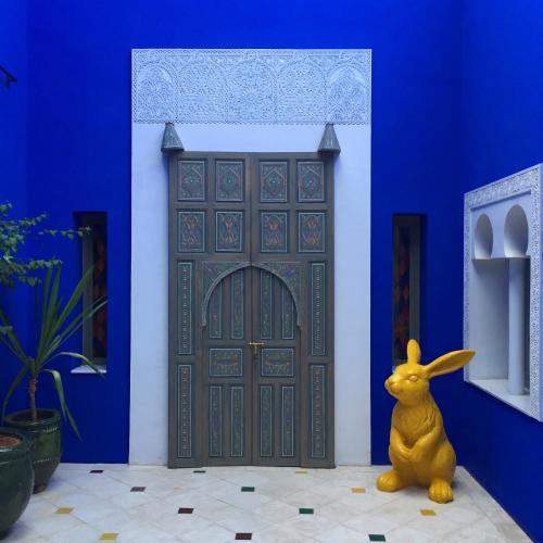 a yellow bunny sitting in front of a blue door at Riad Goloboy in Marrakech