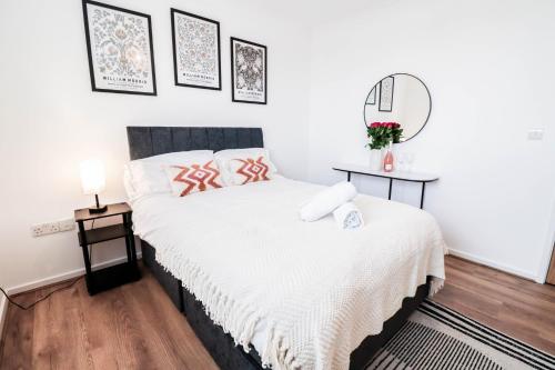 sypialnia z łóżkiem i lustrem na ścianie w obiekcie Fantastic 2 Bed 2nd Floor Flat w mieście Reading