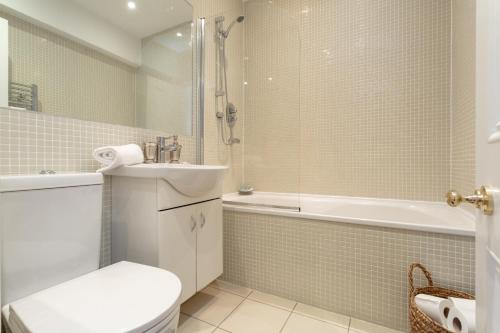 a bathroom with a toilet and a sink and a tub at Spectacular 2 Bedroom Apartment with Sunny Garden & Terrace in Dublin