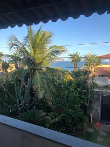 uma varanda com vista para as palmeiras em Casa em frente a praia em Vila Velha