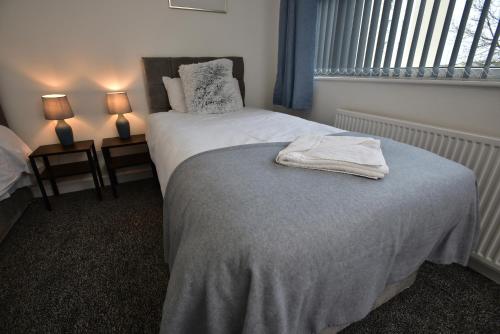 a bedroom with a bed and two lamps and a window at Sedgemoor in Stockton-on-Tees