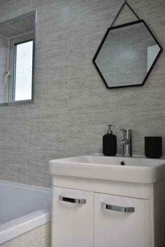 a bathroom with a white sink and a mirror at Sedgemoor in Stockton-on-Tees