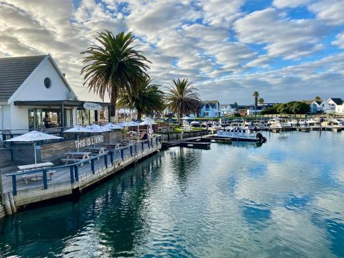 a marina with boats and palm trees on the water at CANAL GUEST HOUSE - Waterfront Accommodation in St Francis Bay