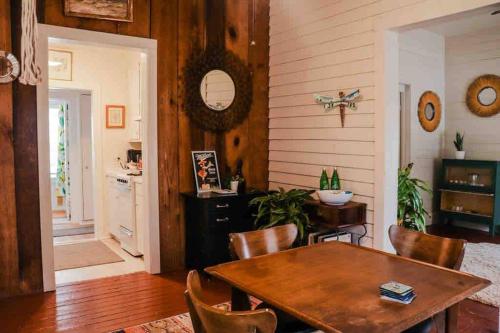 a dining room with a wooden table and chairs at Wensel Cottage in downtown Natchez in Natchez