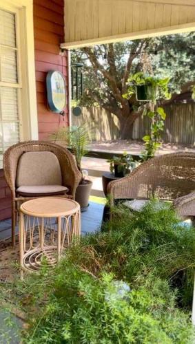 a porch with chairs and a table on a house at Wensel Cottage in downtown Natchez in Natchez
