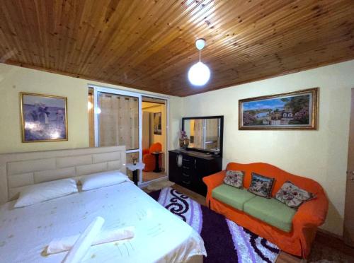 1 dormitorio con 1 cama y 1 sofá en Blue Guesthouse en Gjirokastër