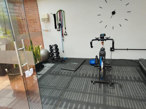 una bicicletta in una stanza con un orologio sul muro di Orange Suites by Vibra Bonita a Medellín