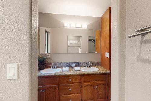 een badkamer met 2 wastafels en een grote spiegel bij The Cozy Sunset Chalet in Oakhurst
