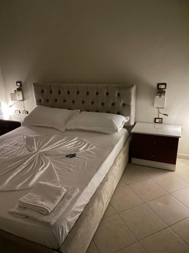 sypialnia z dużym białym łóżkiem i szafką nocną w obiekcie "Nako" apartment w Tiranie