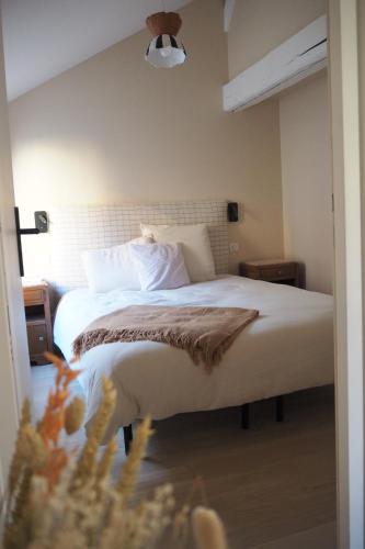 1 dormitorio con 1 cama con sábanas y almohadas blancas en Les baleines - hypercentre 2 chambres avec garage et clim - air conditioning, en Grenoble