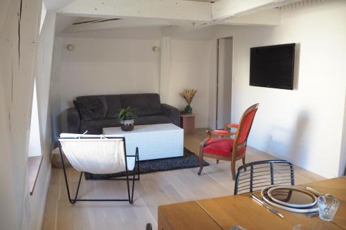 a living room with a couch and a table at Les baleines - hypercentre 2 chambres avec garage et clim - air conditioning in Grenoble