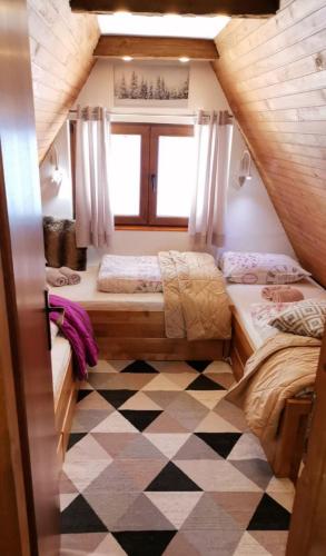a bedroom with two beds and a checkered floor at Planinska idila - uz stazu in Jahorina