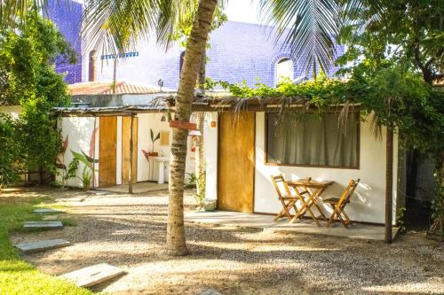 a house with two chairs and a table outside at Indiana Kite school and Hostel in Cumbuco