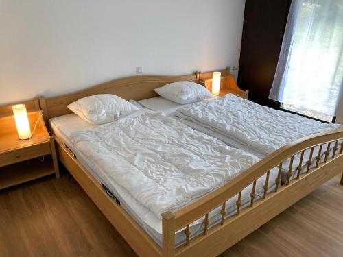 a bed in a bedroom with two lamps on it at Apartment Henri in Schönwald