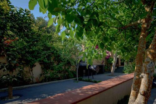 a garden with trees and a brick walkway at N A P L house in Keramiaí