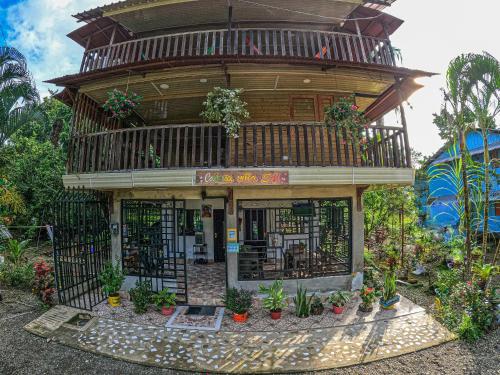 a building with a balcony with plants on it at Cabaña Villa Sofi in Nuquí