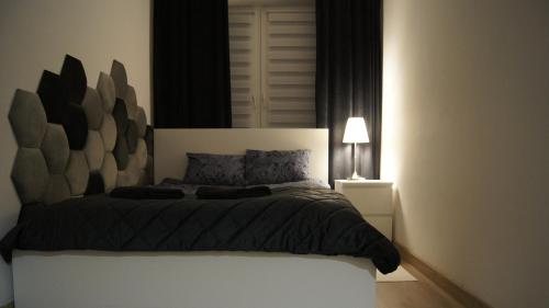 1 dormitorio con 1 cama con cabecero grande en Chemików Point by sleepwell, en Nowy Dwór Mazowiecki