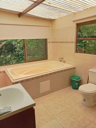 uma casa de banho com uma banheira, um WC e uma janela. em Casa Ecoturística, Disfruta de la Naturaleza , Avistamiento de Aves, Reserva Natural, Cascadas, Restaurantes Típicos , a una hora de Bogotá. em San Antonio